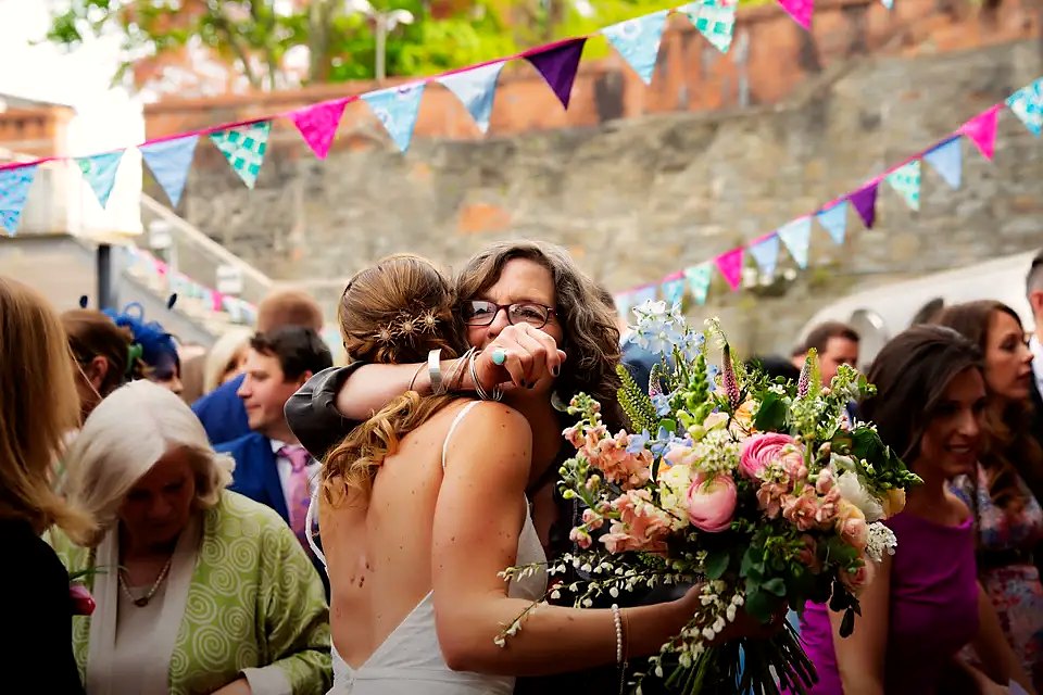 Bride embracing a guest amid bunting